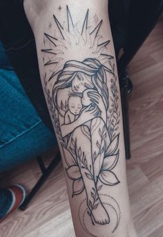 a woman's arm with a tattoo on it that has an image of a mother and child