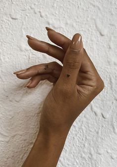 a woman's hand with two fingers on the wall