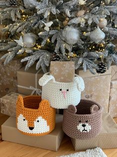 three crocheted baskets sitting in front of a christmas tree