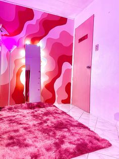 a room with pink walls and carpeted flooring in front of a mirror that has lights on it