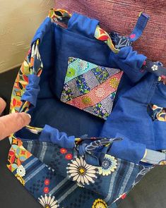 someone is holding the inside of a patchwork tote bag