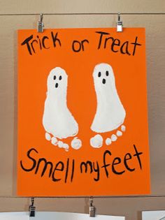 a sign that says trick or treat smell my feet and two ghost hands on an orange background