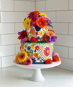 a multi - tiered cake decorated with colorful flowers