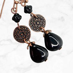 Perfect black teardrop dangle earrings in copper. Richly detailed antiqued copper Mandala flower discs suspend jet black Czech glass teardrop beads.  These earrings go with everything from jeans to a little black dress. A wardrobe must-have! - Hypoallergenic ear wires (nickel and lead free). Choose ear wire style at checkout.  - Free gift packaging included. Earrings are carded and in a gift bag. - Artisan glass beads produced in small quantities in the Czech Republic. Available in ANTIQUE SILVE Nickel-free Czech Glass Teardrop Earrings, Black Bohemian Teardrop Dangle Earrings, Metal Teardrop Earrings With Lever Back, Handmade Black Bohemian Teardrop Earrings, Bronze Metal Teardrop Earrings, Black Bohemian Teardrop Earrings For Gift, Black Bohemian Teardrop Earrings As Gift, Bohemian Black Teardrop Earrings As Gift, Metal Teardrop Dangle Earrings With Lever Back