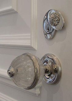 two glass door knobs on the side of a white door