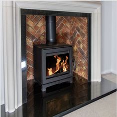 a wood burning stove sitting inside of a fireplace