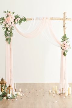 a wedding arch decorated with flowers and candles