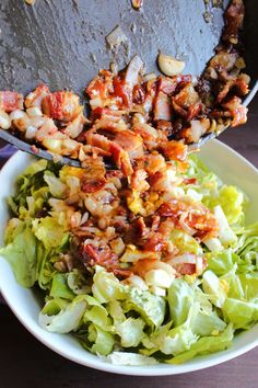 a salad with bacon and lettuce in a white bowl