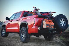 a red truck with an atv on the back