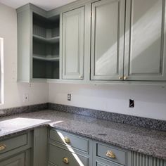 a kitchen with gray cabinets and granite counter tops