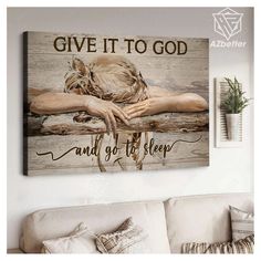 a living room with a couch and a painting on the wall that says give it to god