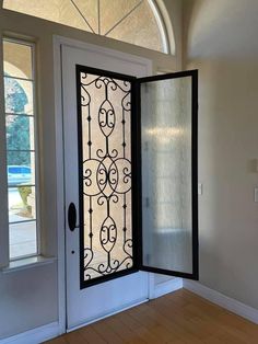 an open door in the middle of a room with wooden floors and windows on both sides