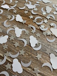 paper cut outs with stars and moon shapes on a wooden surface, ready to be used as decorations