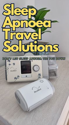 a white alarm clock sitting on top of a wooden table next to a flower pot