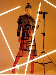 a woman is standing in front of a camera and posing for a photo with her hands on the tripod