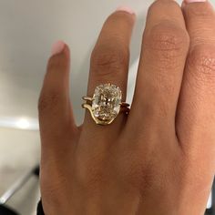 a close up of a person's hand wearing a ring with a diamond on it