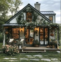 a small house with lots of flowers on the porch