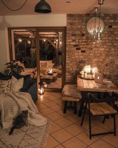 a living room filled with lots of furniture next to a brick wall covered in candles