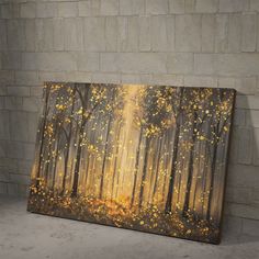 an abstract painting of trees with yellow leaves on them in front of a brick wall