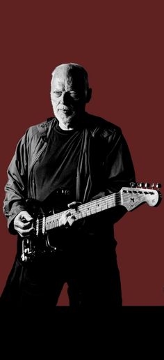 a man holding a guitar in front of a red background