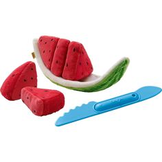 the watermelon slice is next to a knife and toothbrush for brushing teeth