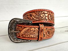 Leather Western style belt with removable buckle.  The border is more of a burnt orange / camel leather color with neutral two tone leather tooling Belt Sizes 1.75" wide  Small 29"-32" Medium 32"-36" Large 36"-40" XL 40"-44" (buckle is removable with screws) handmade and painted leather tooled and painted by American Darling  Not customizable Embroidered Leather Belt For Western-themed Events, Leather Embroidered Belt For Western-themed Events, Leather Belt With Embroidery For Western-themed Events, Hand-tooled Brown Belt Buckles For Western-themed Events, Hand Tooled Leather Belt Buckles For Rodeo, Hand Tooled Leather Belts For Western-themed Events, Brown Hand Tooled Belt Buckles For Rodeo, Hand Tooled Brown Belt Buckles For Rodeo, Brown Leather Rodeo Belt