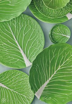 green leafy plates are arranged on a blue tablecloth with white trimmings