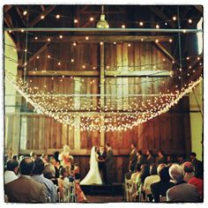 a bride and groom standing at the end of their wedding ceremony in an old barn