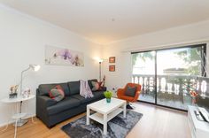 a living room filled with furniture and a flat screen tv sitting on top of a hard wood floor