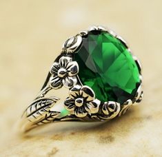 This vintage simulated emerald ring features a stunning 12x10mm stone set in solid 925 sterling silver with intricate floral detailing. The ring is stamped with the hallmark "925," indicating its authenticity and quality. It is a unique and elegant piece that showcases both the beauty of the emerald stone and the craftsmanship of the sterling silver design. Elegant Vintage Wedding, Wedding Rings Unique Vintage, Vintage Wedding Ring, Elegant Wedding Rings, Wedding Ring Unique, Unique Holiday Gifts, Silver Design, Anniversary Present, Wedding Rings Unique