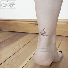 a small sailboat tattoo on the ankle is shown in black ink, and it appears to be tiny