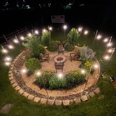 an outdoor fire pit surrounded by landscaping lights