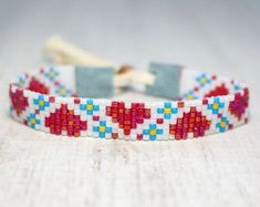 a red, white and blue beaded bracelet sitting on top of a table