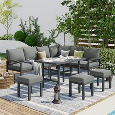 an outdoor patio with grey furniture and white rugs