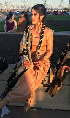 a woman is sitting on the curb with other people