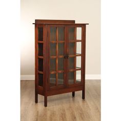 a wooden cabinet with glass doors on the top and bottom shelves, sitting on a hard wood floor