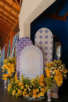 yellow flowers are in vases next to a white and blue sign that says welcome to grand solita