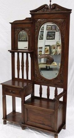 an antique wooden vanity with mirror and shelf