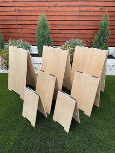 four pieces of plywood sit in the grass