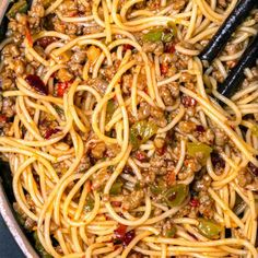 spaghetti with meat and vegetables in a skillet, ready to be cooked for dinner