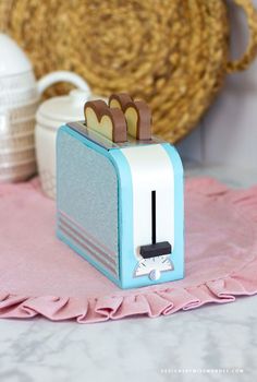 a blue and white toaster sitting on top of a pink towel