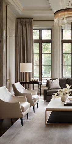 a living room filled with lots of furniture and large windows covered in draping