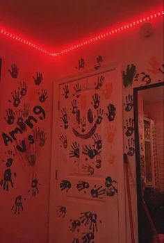 handprints are on the wall next to a door with red lights above it