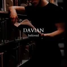 a man leaning against a book shelf in a library reading a book with the words davani below him