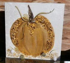 a card with a golden pumpkin on it's front and side, sitting on a table