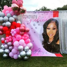 balloons and decorations are set up in the grass for a graduation party with a photo on it