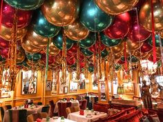 a room filled with lots of tables covered in balloons