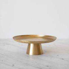 a gold plate sitting on top of a marble countertop next to a white wall