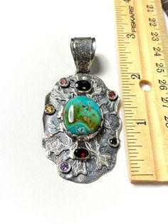 "ARTISAN TURQUOISE TOURMALINE PENDANT Hand-made Sterling Silver 925. Stones used: Turquoise(Nevada), Green Tourmaline, Pink Tourmaline, Red Sapphire, Citrine, Amethyst, Garnet. Height -2 3/4\" (including bail), Width - 1 6/16\" Height - 72mm (including bail), Width - 35mm Unique Handcrafted One-of a-kind Design Pendant Each Piece of Jewelry in my Collection is Absolutely One of a Kind! When you start wearing a piece of my jewelry you will fall in love with it more and more each day and feel that Artisan Turquoise Stone Necklace, Artisan Multicolor Turquoise Pendant Necklace, Bohemian Multi-stone Pendant Gemstones, Unique Multicolor Turquoise Pendant Necklace, Unique Multi-stone Turquoise Gemstones, Turquoise Multi-stone Pendant Necklace As Gift, Artisan Turquoise Pendant Necklace, Handmade Multicolor Sterling Silver Turquoise Necklace, Artisan Turquoise Necklace With Round Pendant