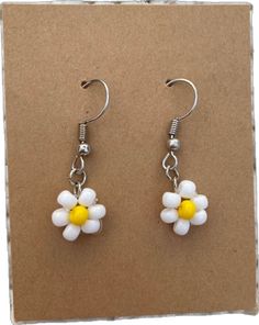 White Daisy Flower Earrings For Spring, White Daisy-shaped Hypoallergenic Flower Earrings, Nickel-free Flower Earrings For Summer, Cute White Beaded Dangle Earrings, White Daisy Flower Charm Earrings, Dainty Daisy-shaped Earrings With Flower Charm, Dainty Flower Earrings With Ear Wire For Summer, Handmade Dainty Flower Earrings For Summer, Summer Daisy Flower Earrings Gift